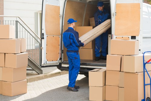 Professional team handling piano removals in Croydon with protective equipment