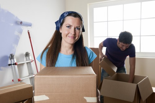 Mover wearing PPE while carrying boxes safely in Croydon