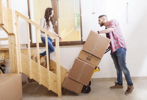 Staff using careful lifting techniques with furniture and boxes